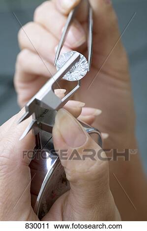 A jeweler using a diamond gauge on a diamond View Large Photo Image Stock Image - A jeweler using a diamond gauge on a diamond. Fotosearch