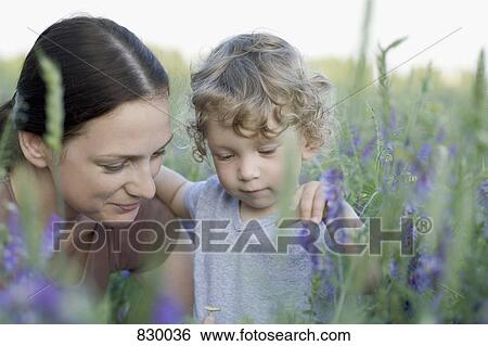 A woman and a young boy together in a field View Large Photo Image Stock Photograph - A woman and a young boy together in a field. Fotosearch