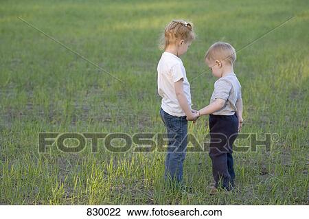 A young sister and brother holding hands, outdoors View Large Photo Image Stock Image - A young sister and brother holding hands, outdoors. Fotosearch