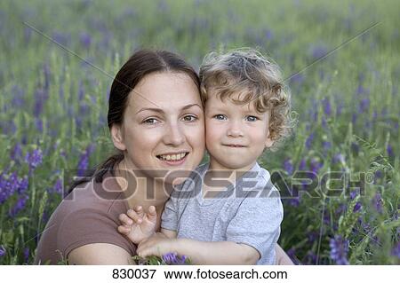 Portrait of a woman and a young boy together in a field View Large Photo Image Stock Photo - Portrait of a woman and a young boy together in a field. Fotosearch