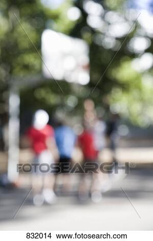 Picture - People playing basketball, outdoors, defocused. Fotosearch
