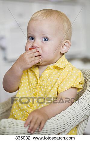 Stock Image - A toddler eating a strawberry. Fotosearch