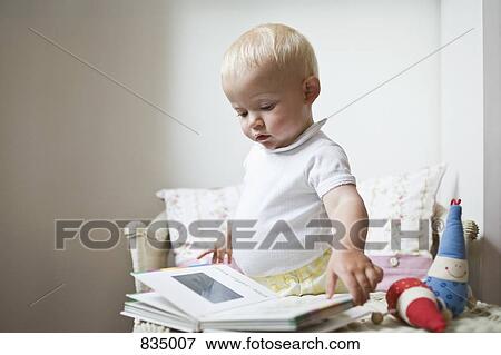 Stock Photo - A toddler looking at a picture book. Fotosearch