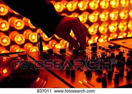 A DJ adjusting levels on a sound mixer at a nightclub View Large Photo Image Stock Image - A DJ adjusting levels on a sound mixer at a nightclub. Fotosearch