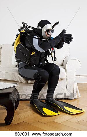 A scuba diver diving off a couch in a living room View Large Photo Image Stock Image - A scuba diver diving off a couch in a living room. Fotosearch