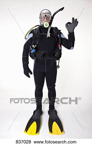 Stock Photo - A scuba diver giving the OK sign, studio shot. Fotosearch