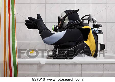 A scuba diver sitting in a bathtub preparing to dive in View Large Photo Image Stock Image - A scuba diver sitting in a bathtub preparing to dive in . Fotosearch
