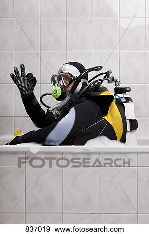 A scuba diver sitting in a bubble bath giving the OK sign View Large Photo Image Stock Photo - A scuba diver sitting in a bubble bath giving the OK sign. Fotosearch