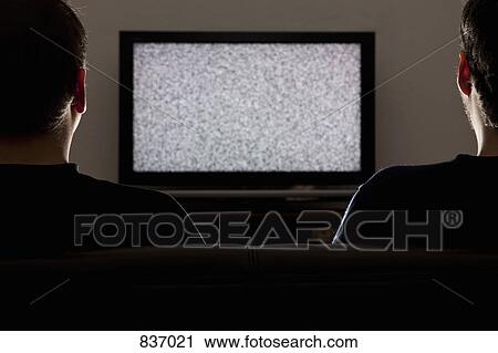 Two men watching a static on a television View Large Photo Image Stock Image - Two men watching a static on a television. Fotosearch