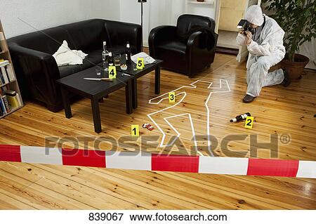 Stock Photo - A person photographing a crime scene. Fotosearch