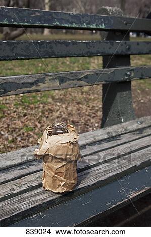 Picture - Bottle in a brown paper bag on a park bench, Brooklyn, New York City, NY, USA. Fotosearch