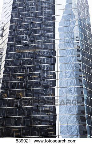Stock Image - Skyscraper with distorted reflection of buildings, Manhattan, New York City, NY, USA. Fotosearch