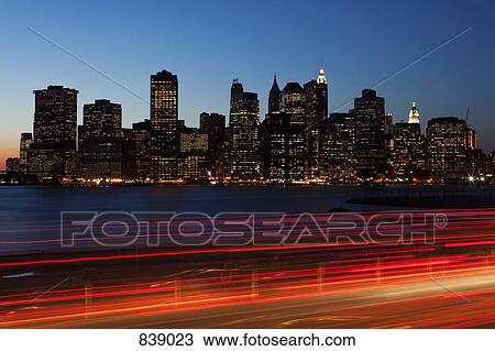 Stock Image - Traffic and cityscape at dusk, Manhattan, New York City, NY, USA. Fotosearch