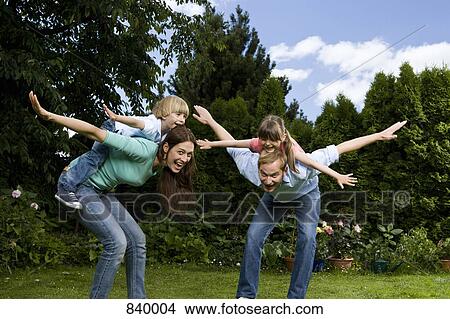 A father, mother and their son and daughter all pretending to be planes View Large Photo Image Picture - A father, mother and their son and daughter all pretending to be planes. Fotosearch
