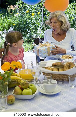 A grandmother and her granddaughter celebrating a birthday View Large Photo Image Stock Image - A grandmother and her granddaughter celebrating a birthday. Fotosearch