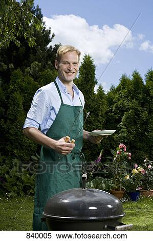 A man barbecuing in a back yard View Large Photo Image Stock Photography - A man barbecuing in a back yard. Fotosearch