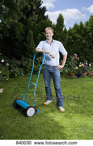 A man leaning on a push mower View Large Photo Image Stock Image - A man leaning on a push mower. Fotosearch