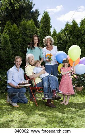 A multi-generational family celebrating a birthday, outdoors View Large Photo Image Stock Image - A multi-generational family celebrating a birthday, outdoors. Fotosearch