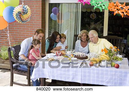 A multi-generational family celebrating a birthday, outdoors View Large Photo Image Stock Image - A multi-generational family celebrating a birthday, outdoors. Fotosearch