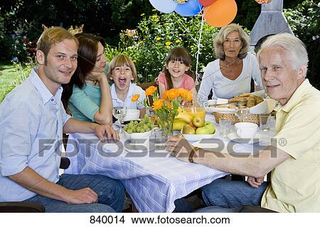 A multi-generational family having breakfast, outdoors View Large Photo Image Picture - A multi-generational family having breakfast, outdoors. Fotosearch