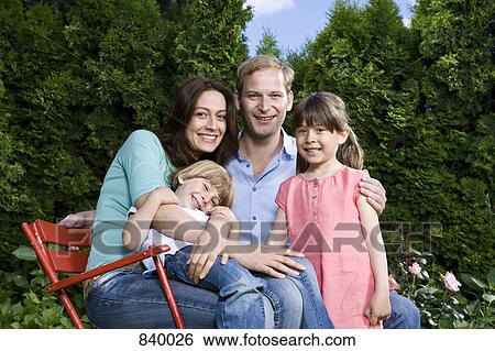 Stock Photograph - A portrait of a mid adult couple and their two young children. Fotosearch
