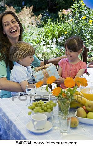 Picture - A sister giving her brother a birthday present. Fotosearch