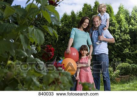Stock Image - Portrait of a mid adult couple and their two small children. Fotosearch