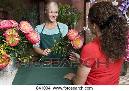 A woman buying flowers in a florists View Large Photo Image Picture - A woman buying flowers in a florists. Fotosearch