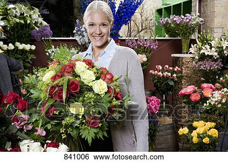 A woman holding a bouquet of flowers in a florists View Large Photo Image Stock Photograph - A woman holding a bouquet of flowers in a florists. Fotosearch