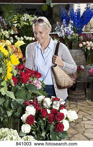 A woman looking at flowers in a florists View Large Photo Image Stock Image - A woman looking at flowers in a florists. Fotosearch