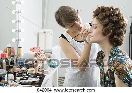 Picture - A make-up artist applying make-up on a model. Fotosearch