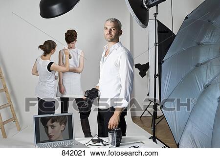 A photographer, model and make-up artist on set of a fashion shoot View Large Photo Image Stock Image - A photographer, model and make-up artist on set of a fashion shoot. Fotosearch