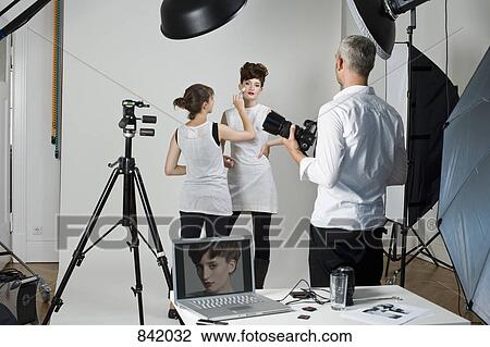 A photographer, model and make-up artist on set of a fashion shoot View Large Photo Image Stock Image - A photographer, model and make-up artist on set of a fashion shoot. Fotosearch