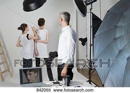 A photographer, model and make-up artist on set of a fashion shoot View Large Photo Image Stock Photography - A photographer, model and make-up artist on set of a fashion shoot. Fotosearch