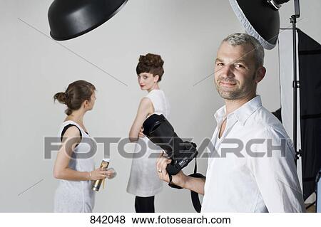 Stock Photo - Portrait of a photographer on a fashion shoot. Fotosearch