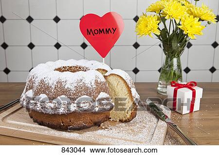 A Bundt cake, flowers and a gift box for Mother's Day View Large Photo Image Picture - A Bundt cake, flowers and a gift box for Mother's Day. Fotosearch