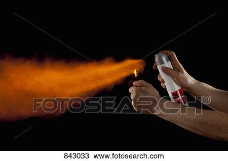 Stock Image - A hand igniting the spray from an aerosol can. Fotosearch