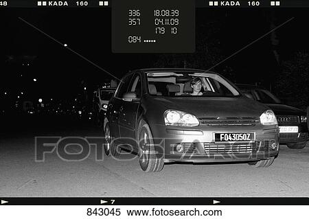 Stock Photography - A woman driver getting caught speeding by a speed camera. Fotosearch