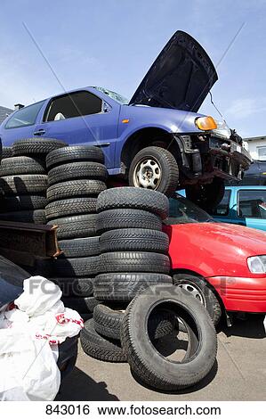 Stock Photograph - Cars and tires in a junkyard. Fotosearch