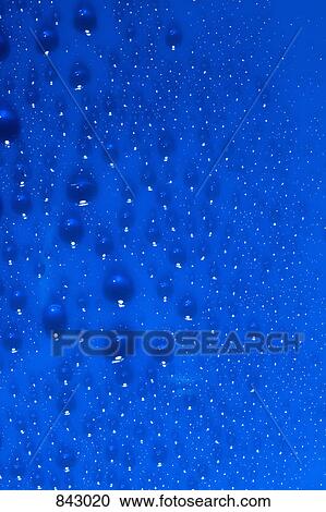 Stock Image - Water drops on a blue surface. Fotosearch