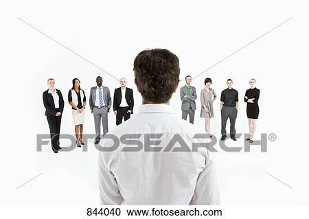 Stock Image - A man standing in front of a row of business people . Fotosearch