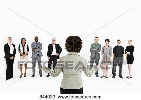 Stock Image - A woman standing in front of a row of business people. Fotosearch