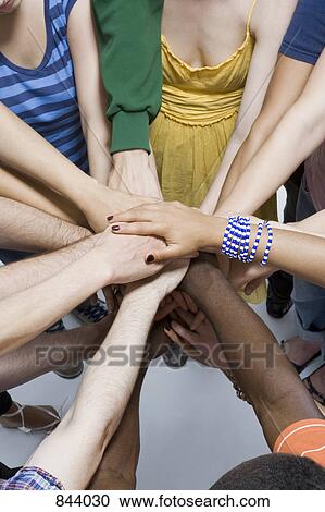 Stock Image - Detail of a group of men and women in a huddle. Fotosearch