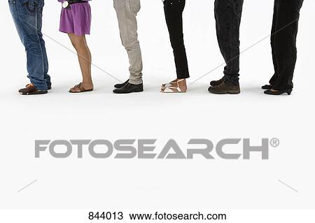 Stock Image - Low section of young adults standing in a line. Fotosearch