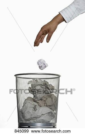 A human hand throwing a crumpled piece of paper into a wastepaper basket View Large Photo Image Stock Photo - A human hand throwing a crumpled piece of paper into a wastepaper basket. Fotosearch