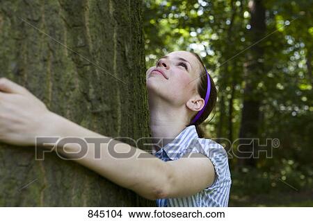 A young woman hugging a tree View Large Photo Image Picture - A young woman hugging a tree. Fotosearch