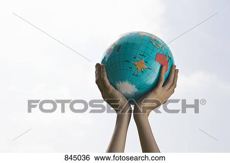 Cupped hands holding a globe up View Large Photo Image Stock Photograph - Cupped hands holding a globe up. Fotosearch