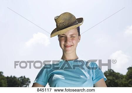 Portrait of a winking young woman wearing a fedora View Large Photo Image Stock Photo - Portrait of a winking young woman wearing a fedora. Fotosearch