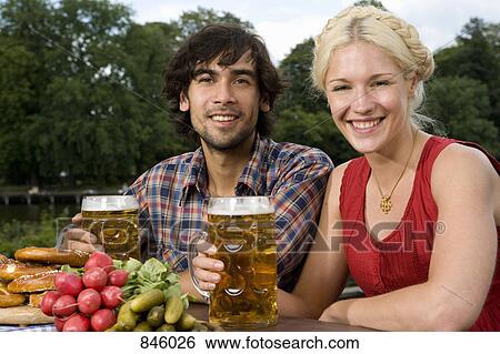 Stock Photograph - A man and a woman sitting in a beer garden. Fotosearch