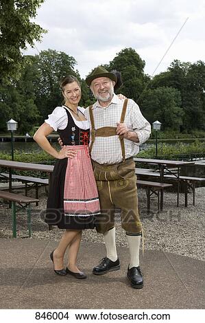 Picture - A traditionally clothed German man and woman in a beer garden. Fotosearch